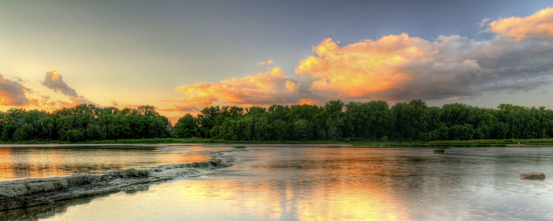 landscape of river, sky and trees at sunset
